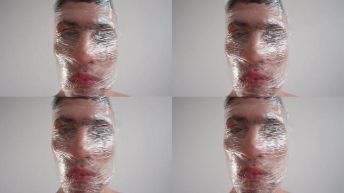 肖像，用保鲜膜包裹男性脸。塑料垃圾的概念问题