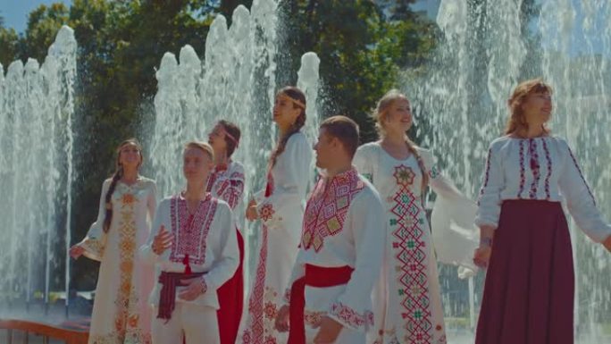 乌克兰妇女和男子穿着民族民间服装，在公园里聊天，他们很高兴。乌克兰人民在公园里散步，人民友好。4k，