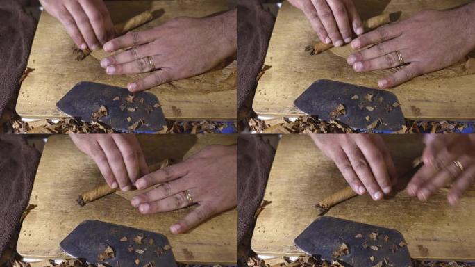 男人的手拧用烟叶制成的雪茄。托尔塞多的工作。