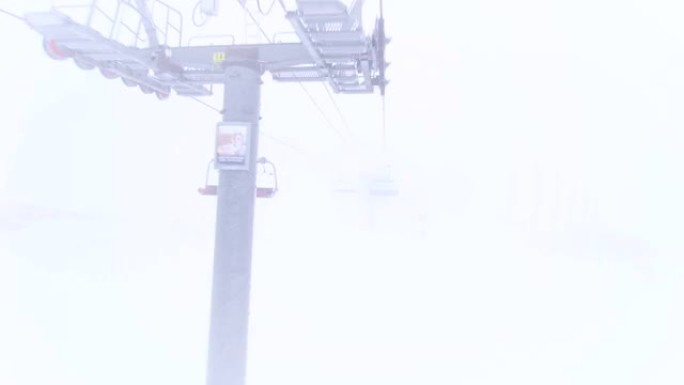 钢缆上的六人升降椅在云中移动。滑雪胜地有雾的天气。加速视频。