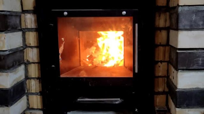木柴在带有玻璃门的小烤箱中燃烧