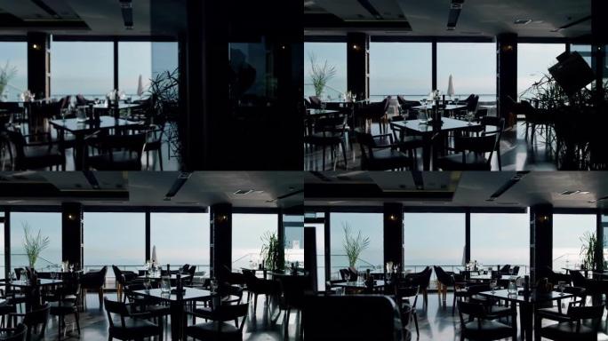 在宽敞的黑暗自助餐厅内部供应午餐桌，可欣赏美丽的海景