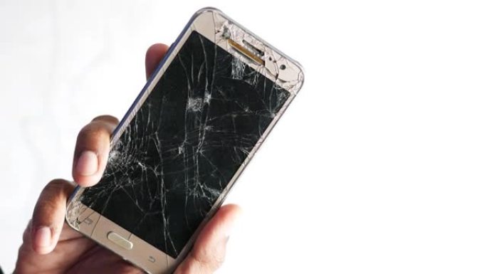 男子手持破碎的智能手机的特写镜头被隔离在白色上