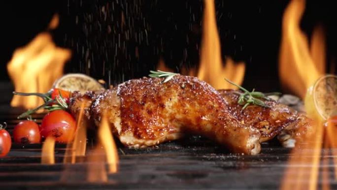 鸡腿在热烧烤木炭火烧烤架上烤，上面撒上香料。在烧烤烤架上烤多汁的鸡肉。慢动作