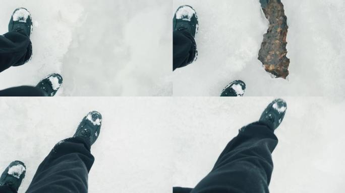 穿着靴子的人的脚在寒冷的冬天在薄冰上行走，溪流在冰下流动