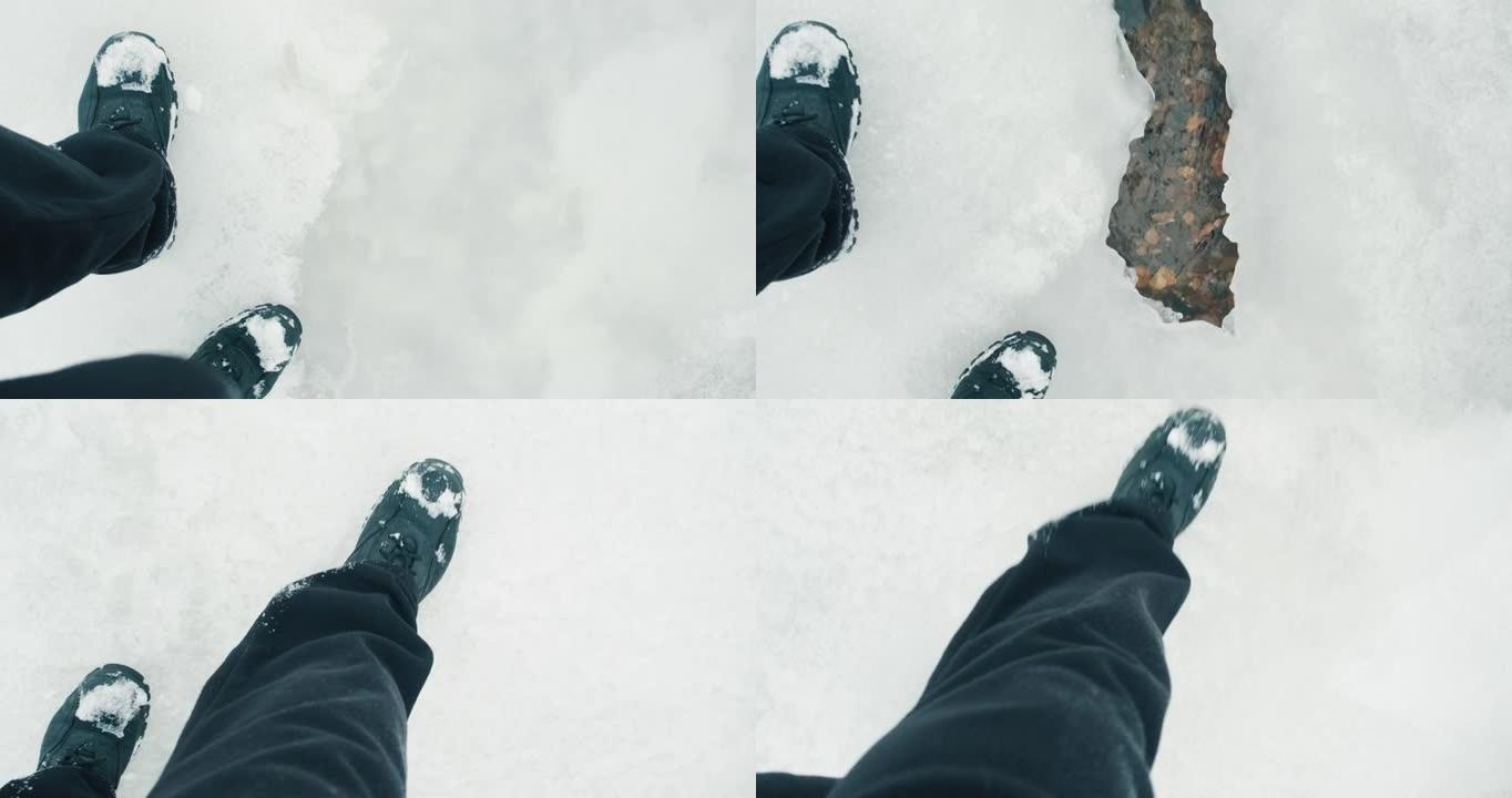 穿着靴子的人的脚在寒冷的冬天在薄冰上行走，溪流在冰下流动