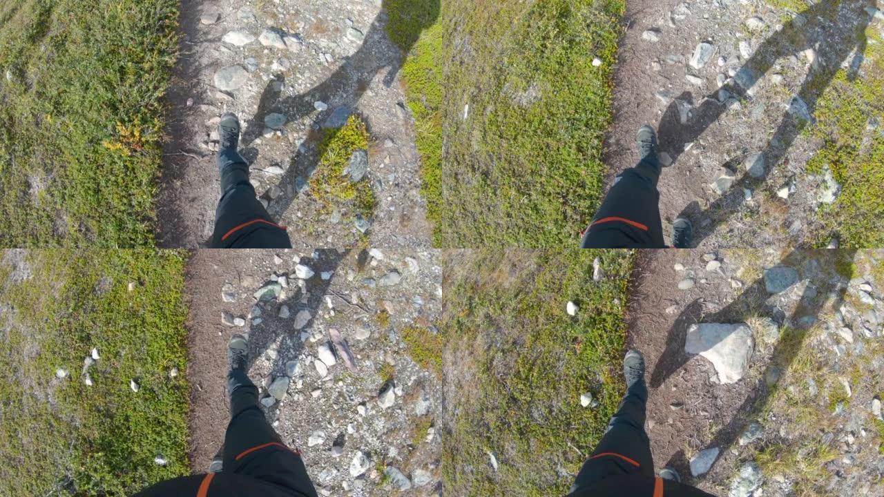 在瑞典北部的大自然中，一个男性徒步旅行者的腿在岩石上行走。