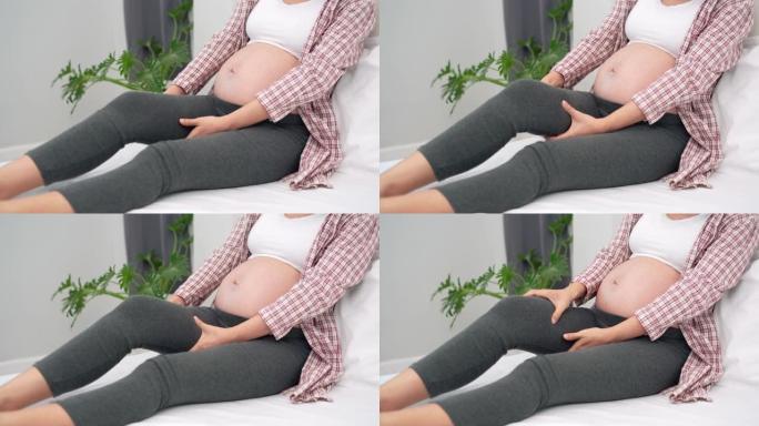 孕妇腿部抽筋，按摩减轻疼痛。抽筋是孕妇的常见症状。孕妇的概念症状。