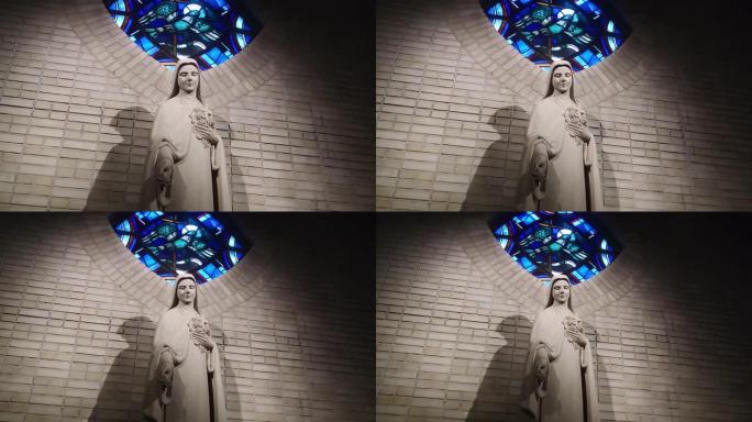 圣母玛利亚的雕像低着头站在室内，看上去笔直。法国巴黎麦当娜雕像上方的蓝光马赛克背后的太阳，欧洲