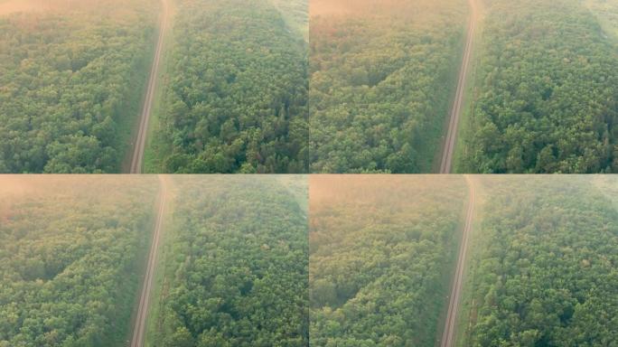 黎明时无人驾驶飞机在一条空铁路上飞行-夏季早晨的铁路鸟瞰图。