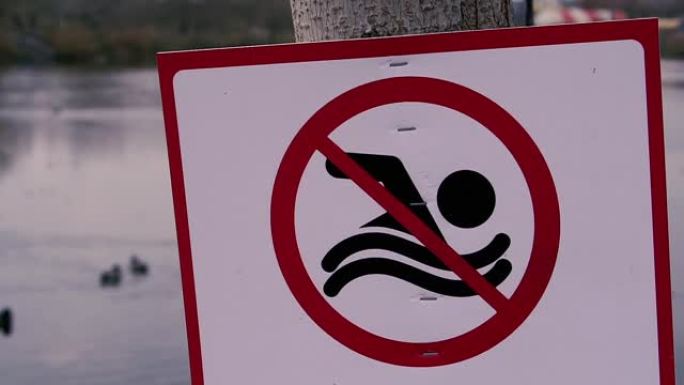 禁止标志。这块牌子禁止在池塘里游泳。