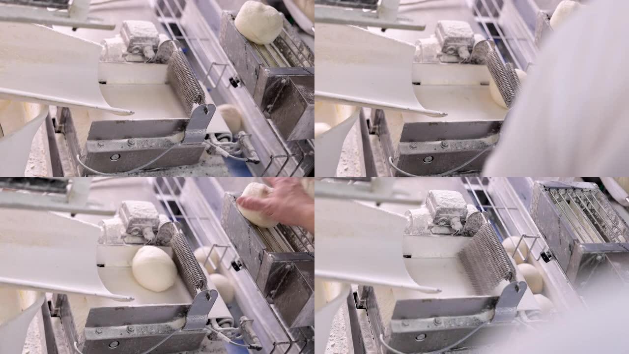 面团卷面机，将面团喷在生产线上，而面包师观察过程