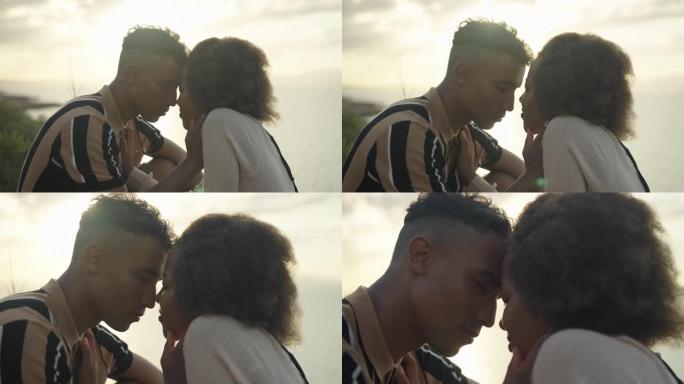 日落时的浪漫约会。两个非洲族裔青少年用爱互相拥抱。年轻的爱