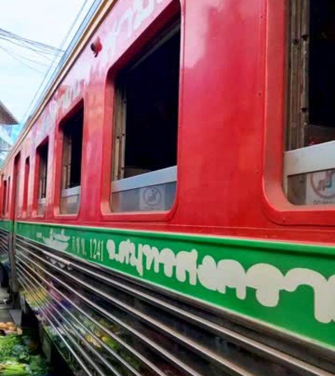 泰国曼谷市场上有火车和卖东西的人的Maeklong铁路市场