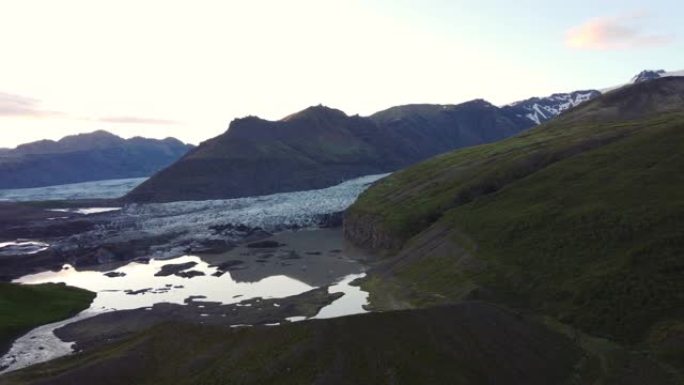日落冰川在冰岛环城拍摄，无人机向前移动冰川湖中的山的倒影。