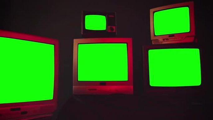 一组5台老式电视，带色度键屏幕，房间内有蓝色黑色墙壁