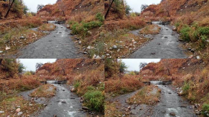 秋天在山河上的电影飞行。山区河流层层叠叠，秋色环绕。无人机在河流上空飞行，从一个小瀑布上方迅速倾泻而