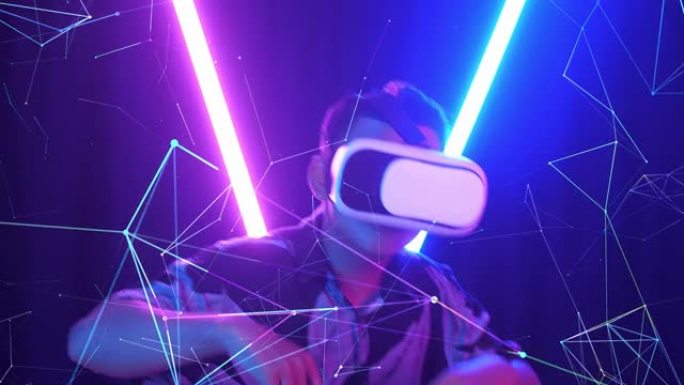 Vr，未来派，娱乐概念。兴奋的亚洲男孩使用虚拟现实耳机和背景霓虹灯有趣的舞蹈