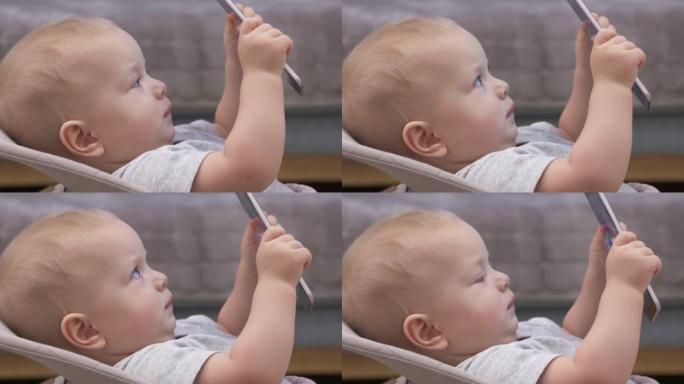使用移动设备玩得开心的孩子，9个月大的男婴在平板电脑屏幕上观看俄罗斯儿童动画电视连续剧BabyRik