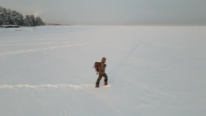 一个背着背包的旅行者走过深雪