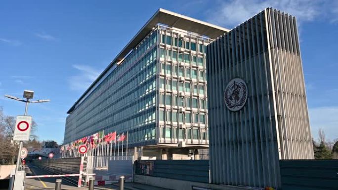 2023年1月，瑞士日内瓦。这是联合国总部的漂亮慢镜头。在右边的标志明显，在左边的旗帜缓缓飘扬。阳光