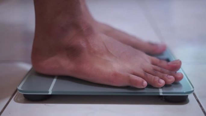B roll-Man脚站立体重秤，检查BMI体重减轻。赤脚测量身体脂肪超重