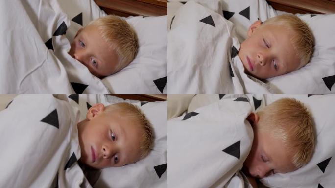 一个发烧的男孩正在家里的床上睡觉，他被毯子覆盖着。