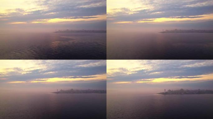 日落时，无人机在平静的海面上驶向灯塔