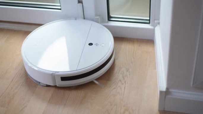 客厅用窗户和墙壁吸尘地板的无线机器人真空吸尘器的俯视图。现代智能电子管家技术的概念。