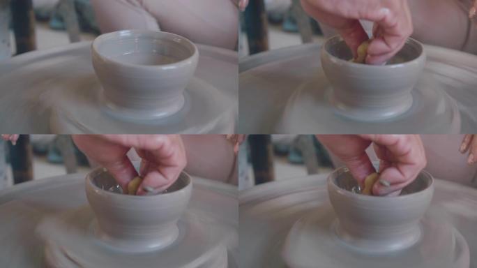 从陶艺轮上的陶艺团块上的女性陶艺塑形壶的镜头