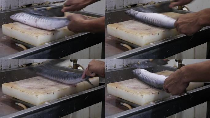 用锋利的刀将新鲜的鱼从鱼鳞上剥下来的特写镜头