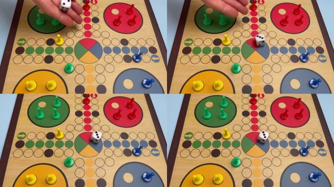在游戏板上扔一个骰子的特写视图。在漂亮的木制棋盘上玩Ludo或Pachisi棋盘游戏。Ludo是两到