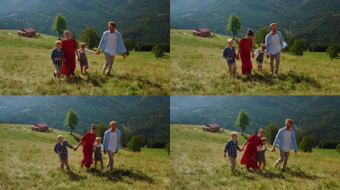一家人步行到绿色的山坡上走绿草。享受大自然的人们。