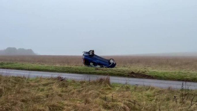 一辆蓝色坠毁的倒车汽车在rivr岸上的无人机镜头
