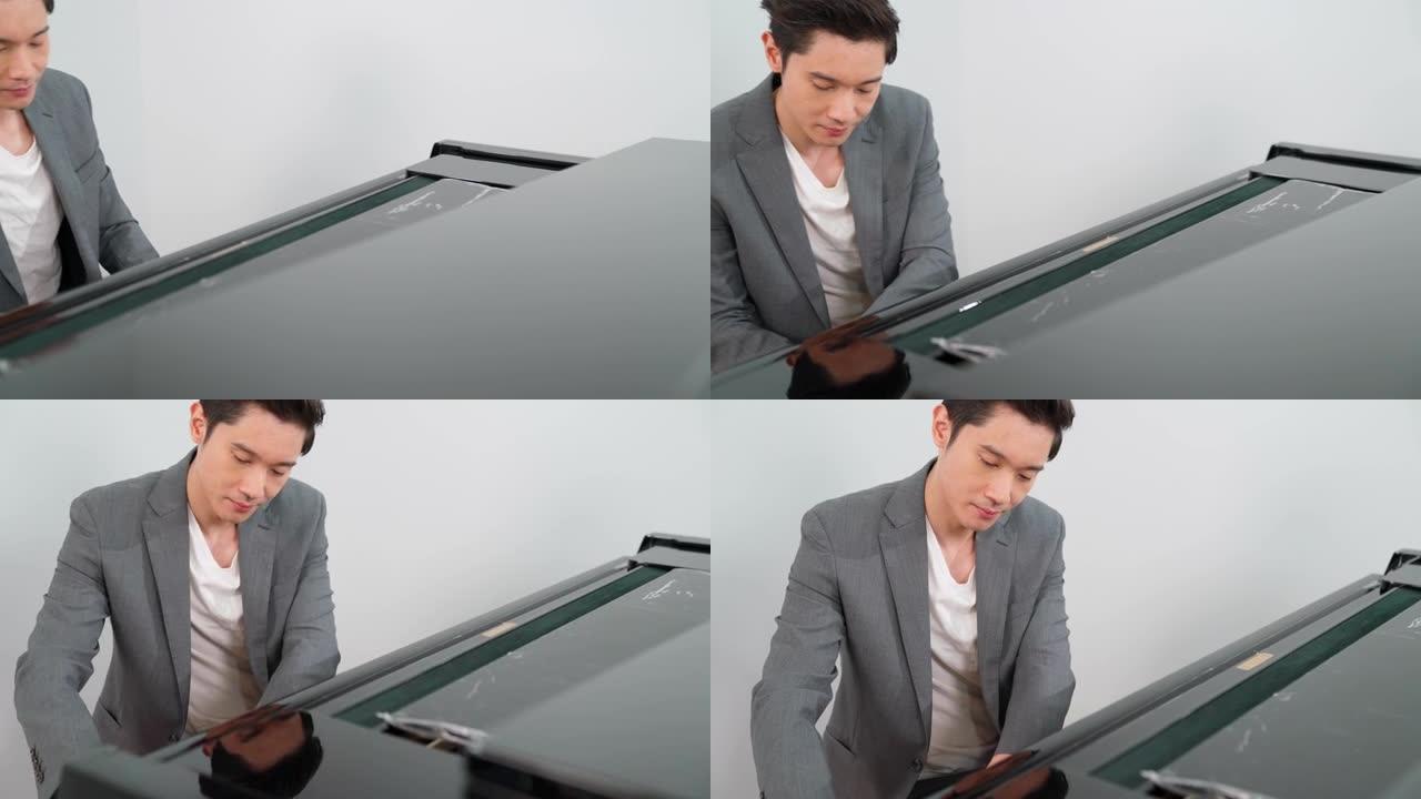 休闲风格的男钢琴家肖像在学校演奏经典三角钢琴。音乐家年轻人在练习钢琴时感到快乐和放松。在线音乐学校业