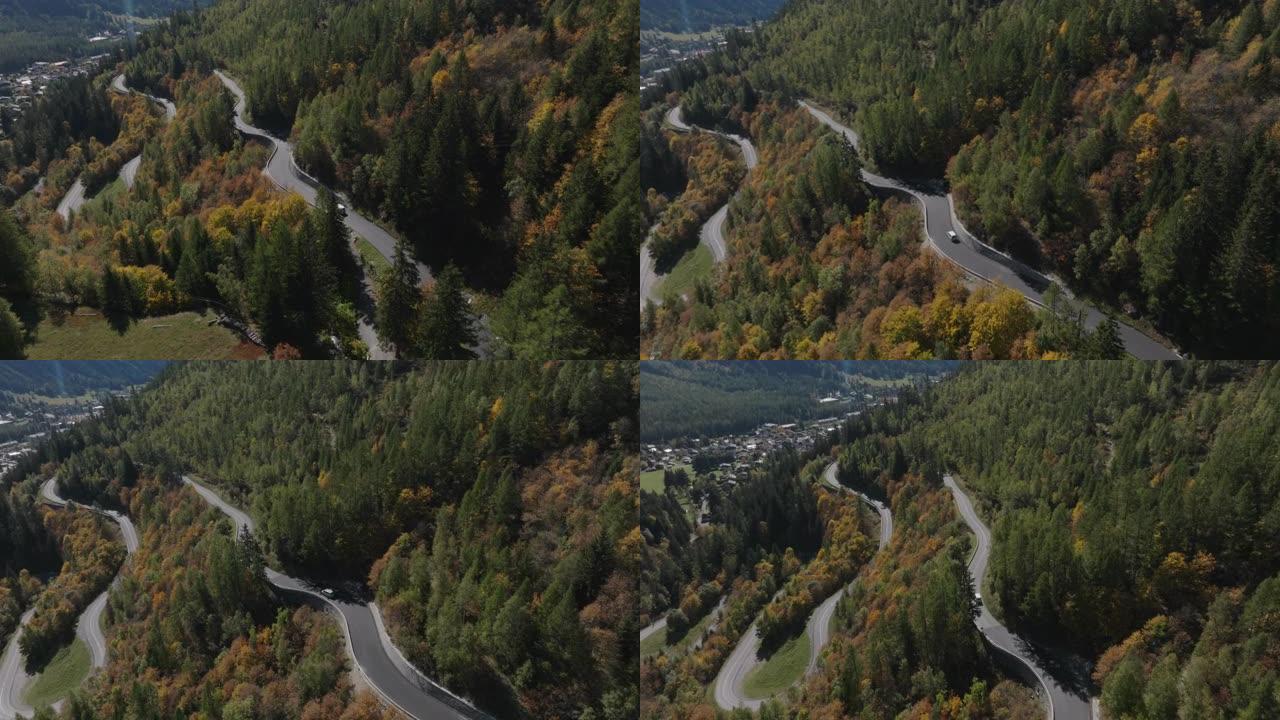 空中无人机在秋天弯曲的山口上拍摄车辆