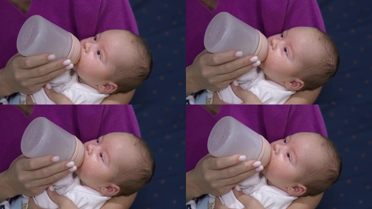 昏昏欲睡的婴儿在瓶子里喝完牛奶。吃饭时，母亲怀里的小孩逐渐入睡。特写。