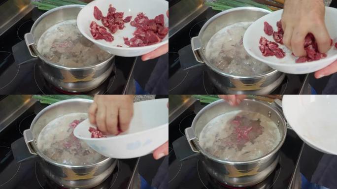 西班牙裔男子将切碎的猪肉放入沸水中。