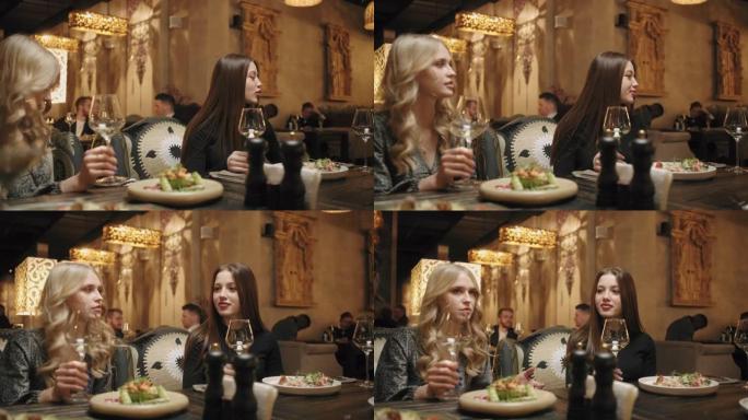 餐厅的客人在大厅里吃饭和喝酒，年轻女性在聊天