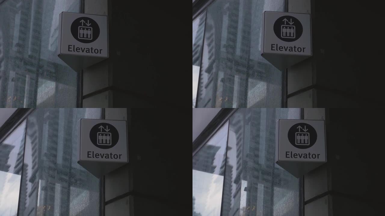 玻璃和混凝土建筑反映了一些摩天大楼，上面有一个电梯标志