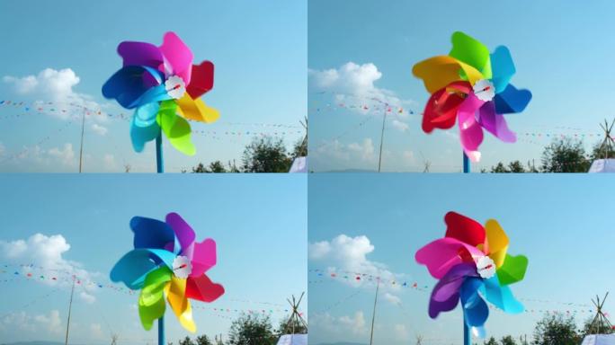 彩色塑料玩具风车在蓝天下随风旋转。自由和生命的象征。