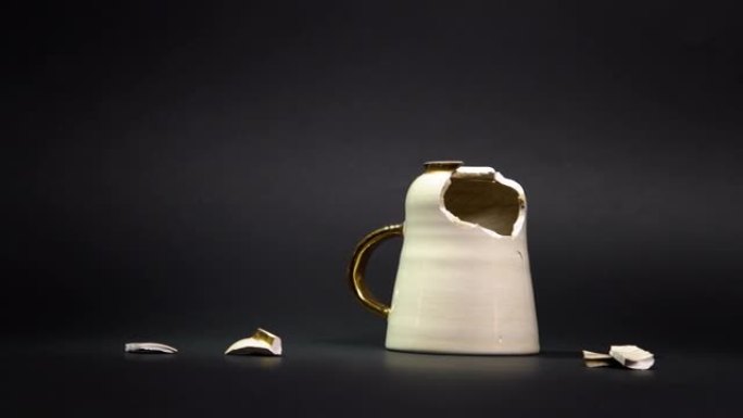 破碎的茶杯孤立在黑色背景上。破裂的咖啡杯和易碎的陶瓷片