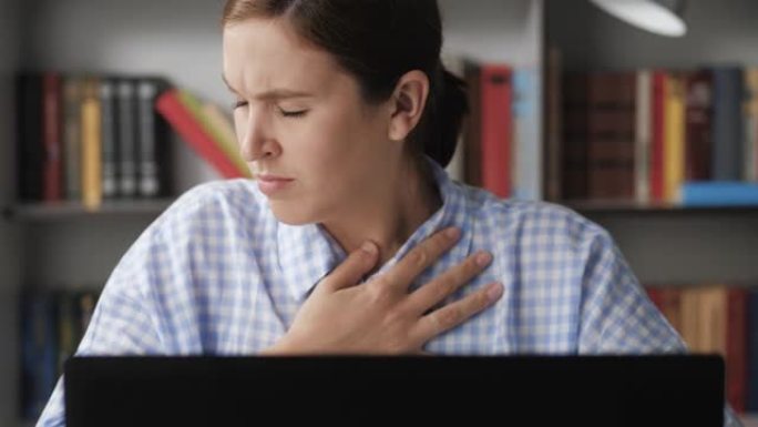 呼吸困难，胸痛。特写镜头在计算机上工作的女性，她呼吸困难或胸部疼痛，用手触摸胸部。惊恐发作，哮喘，骨