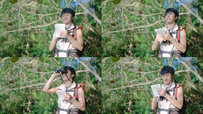 亚洲人类研究人员遍历使用双筒望远镜观察树木，树林中的鸟类，并在笔记本上写下信息以发展知识。在假期快乐