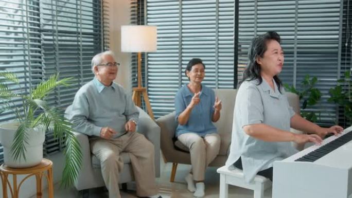 一群亚洲老年人在老年保健中心一起享受音乐、弹钢琴、跳舞