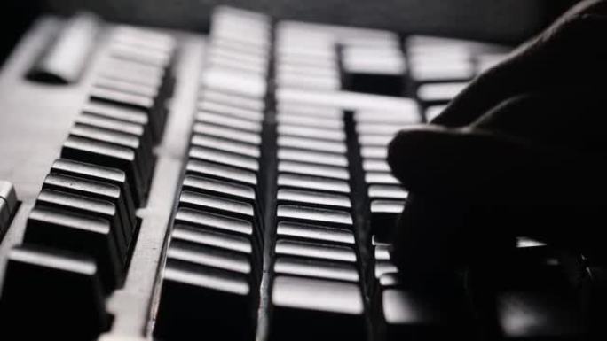 黑客在电脑键盘上打字，特写。在键盘上打字的手的轮廓。