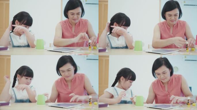 母亲帮助她的孩子为学校的家庭作业制作纸制