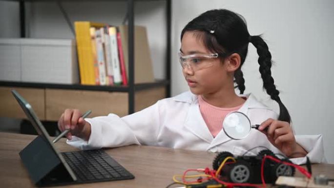 亚洲小女孩在STEM类构建和编码机器人，固定和修理机械玩具车