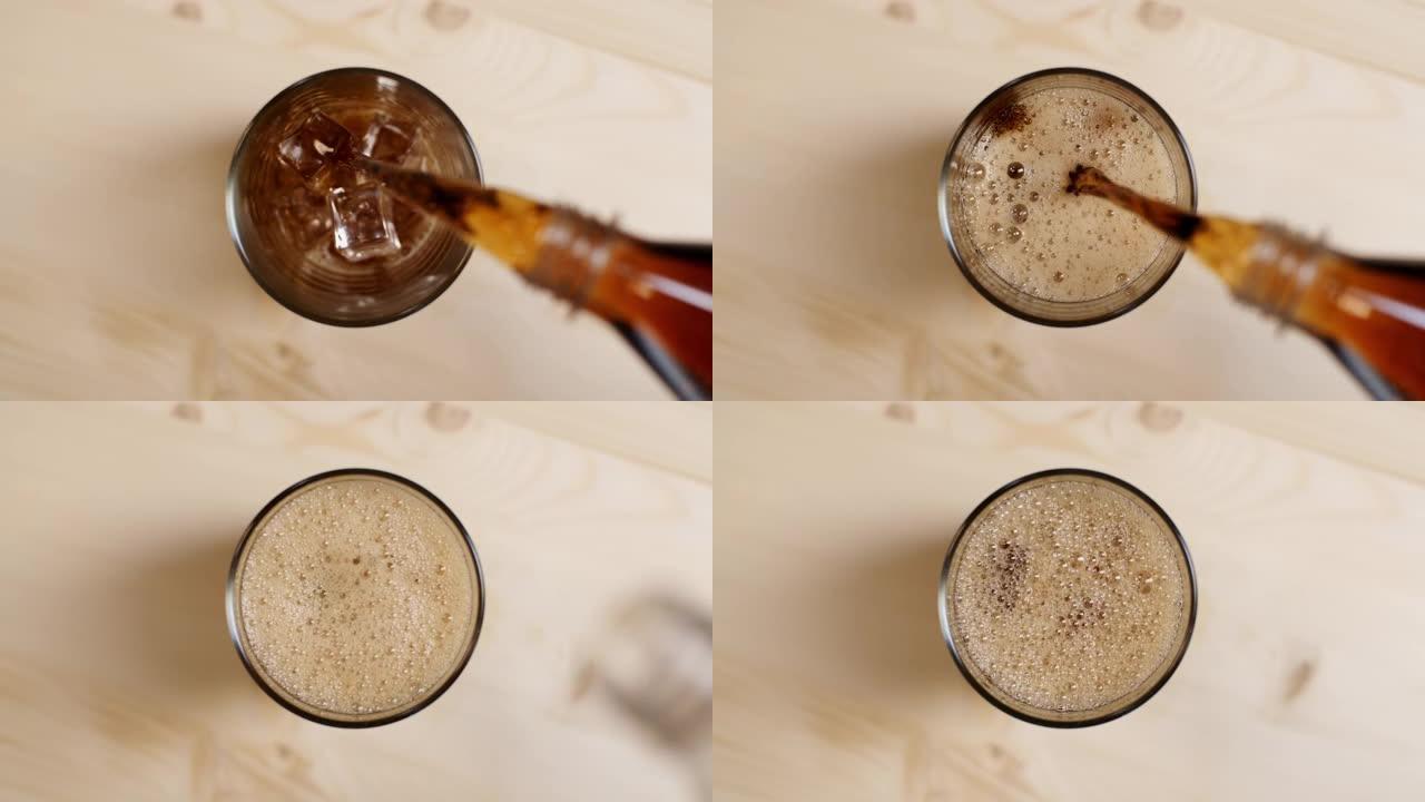 俯视图可乐碳酸饮料倒入玻璃中，冰块放在浅棕色木桌上
