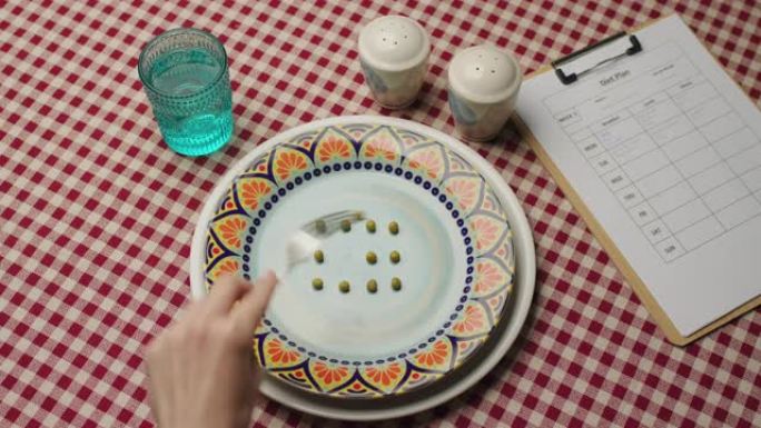 饮食概念。手吃豌豆和写饮食计划，顶视图。